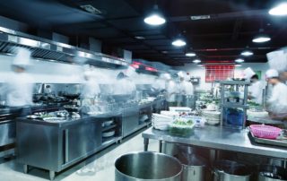Cooks are busily working in a commercial restaurant kitchen