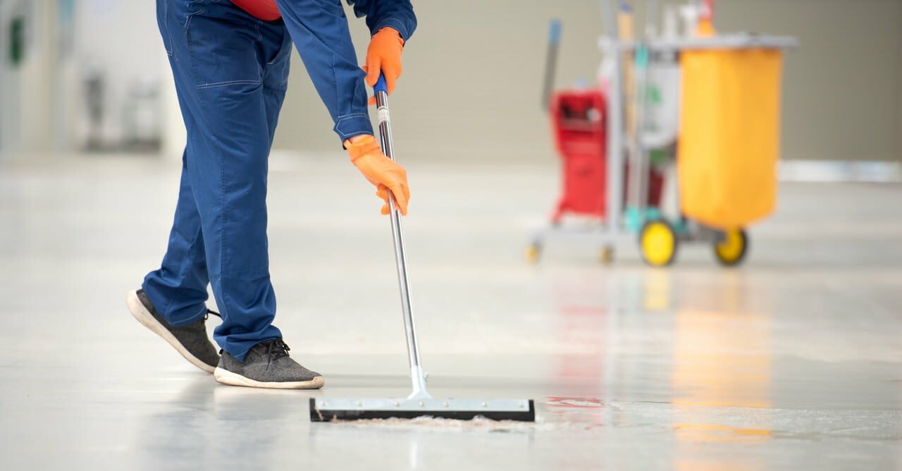 cleaning professional using squeegee mop to wash floor